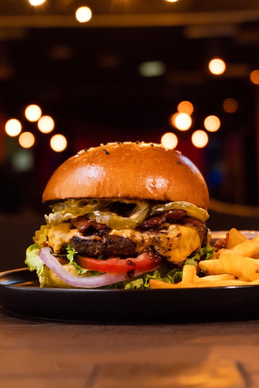 Burger and fries with blurred lights in the background
